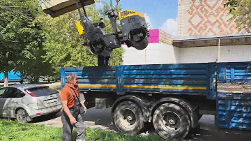 Манипулятор загружает  двухвальцовый  виброкаток GROST VR1000. vibrating roller GROSS VR1000.